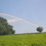 Large sprinkler with rainbow in the background